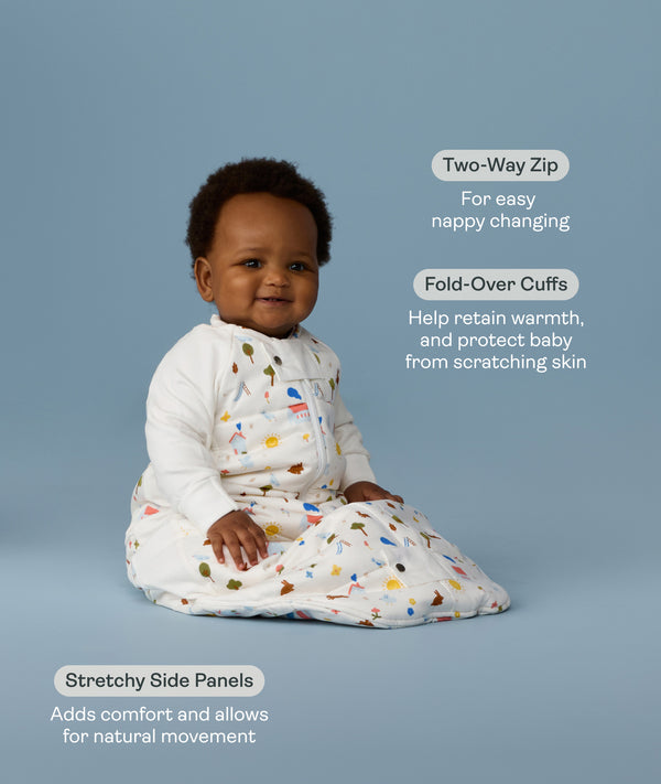 Baby in a white sleeping bag with text about its features on a light blue background