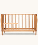 Wooden cot with a minimalist design on a white background