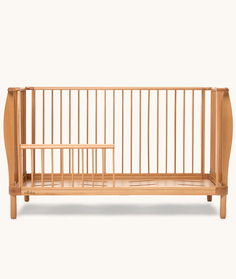 Wooden cot with a minimalist design on a white background