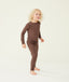 A preschooler standing against a cream background wearing a brown long sleeve pyjama set with matching pants, designed for everyday comfort.