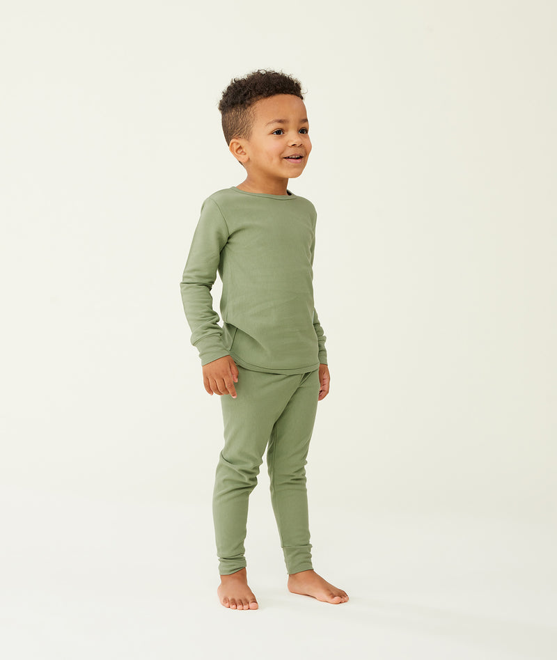 Preschooler wearing an olive green long-sleeve pyjama set with matching pants, made from soft, comfortable fabric.