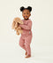 Toddler holding a plush toy wearing a blush pink long-sleeve pyjama set with matching pants, made from soft, comfortable fabric.