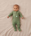 Baby lying on a beige blanket wearing a slim-fit Long Sleeve Layer by ergoPouch, featuring fold over hand and foot cuffs.