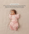 Baby lying on their back in a pink floral-patterned Cocoon Swaddle Bag with a matching Butterfly Cardi, enabling hands-up swaddled sleeping.
