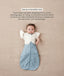 Baby in a blue dragonfly-patterned Cocoon Swaddle Bag with one arm released using a Butterfly Cardi, accompanied by text explaining how to use it as a transition tool.