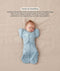 Baby lying on their back in a blue dragonfly-patterned Cocoon Swaddle Bag with a matching Butterfly Cardi, enabling hands-up swaddled sleeping.