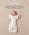 Baby in a cream Cocoon Swaddle Bag with one arm released using a Butterfly Cardi, accompanied by text explaining how to use it as a transition tool.
