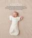 Baby in a cream Cocoon Swaddle Bag with one arm released using a Butterfly Cardi, accompanied by text explaining how to use it as a transition tool.