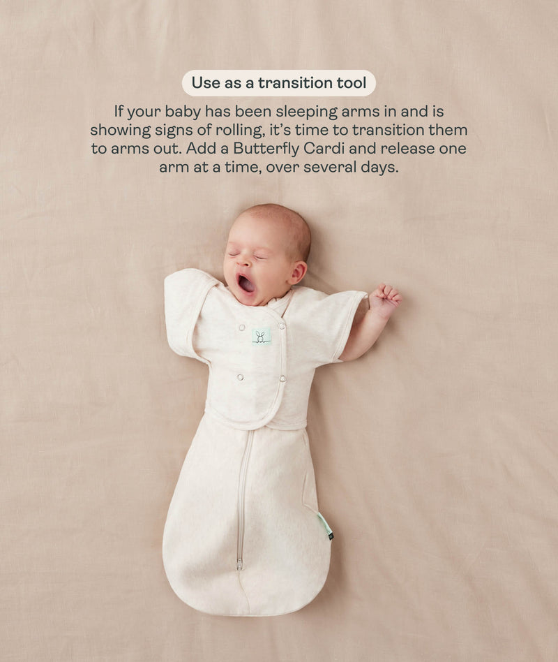 Baby in a cream Cocoon Swaddle Bag with one arm released using a Butterfly Cardi, accompanied by text explaining how to use it as a transition tool.