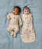Two babies lying side by side wearing Safari-themed Long Sleeve Layer and Cocoon Swaddle Bag.
