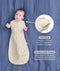 Baby lying on a blue sheet background, wearing a patterned Cocoon Swaddle Bag with callouts highlighting 