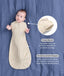 Baby lying on a blue sheet background, wearing a patterned Cocoon Swaddle Bag with callouts highlighting 