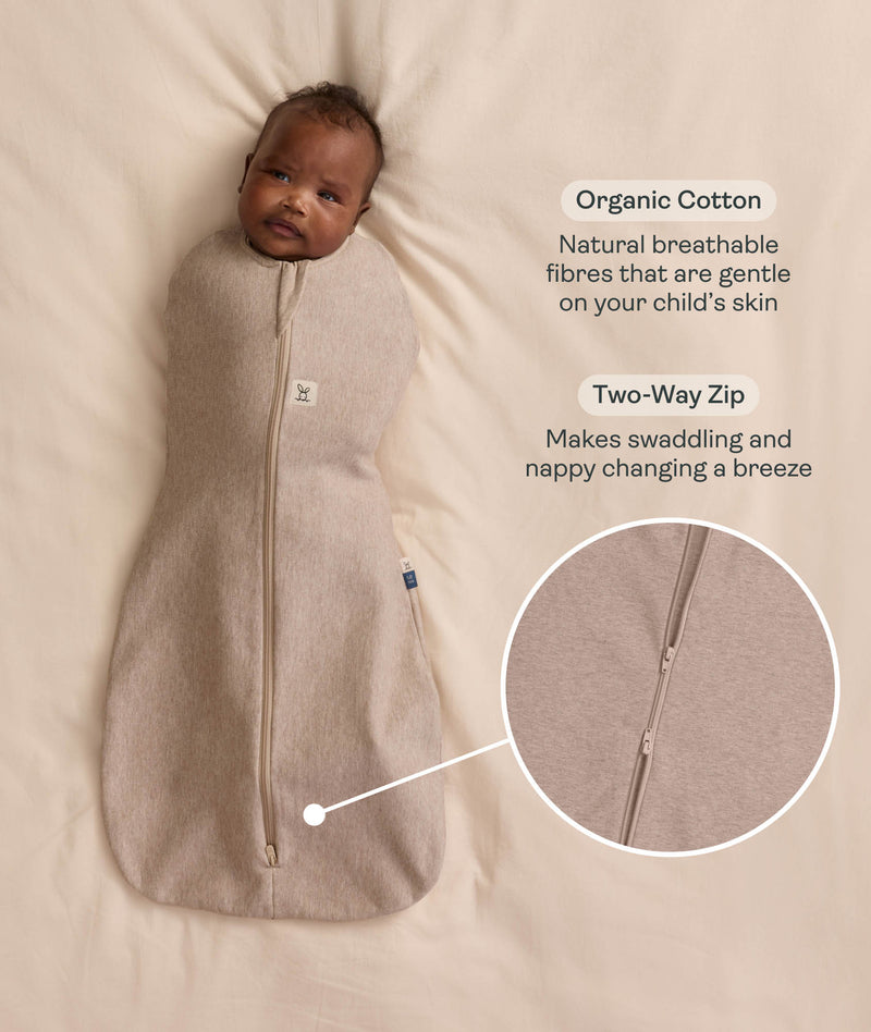 Baby swaddled in a Cocoon Swaddle Bag in Taupe Marle with callouts highlighting 