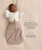 Infant wearing a Cocoon Swaddle Bag  layered with a cream 