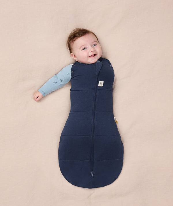 Baby dressed in an ergoPouch Cocoon Swaddle Bag 2.5 TOG with its one arm out.