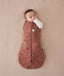 Baby is snugly wrapped in a Cocoon Swaddle Bag with its one arm out