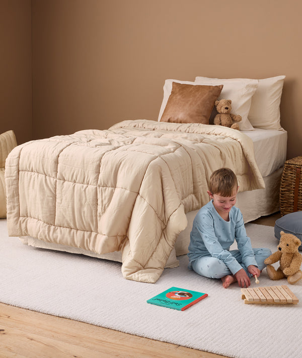 Convertible cotton quilt on single bed with child wearing dragonflies pyjamas