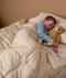 Child sleeping in single bed with convertible cotton quilt