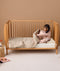 Toddler climbing into bed with convertible quilt