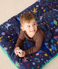 DreamRoll All-in-One Sleep Mat Space Dreams preschooler lying on tummy
