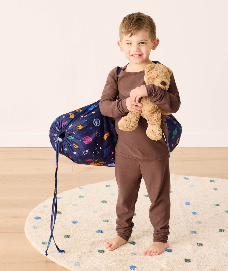 DreamRoll All-in-One Sleep Mat Space Dreams preschooler standing wearing carry bag 
