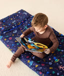 DreamRoll All-in-One Sleep Mat Space Dreams reading a book sitting on the mat