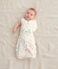 Baby wearing a  0.2 TOG Cocoon Swaddle Bag with its one arm out