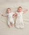 Two babies wearing an ergoPouch Short Sleeve Layer and a Cocoon Swaddle Bag