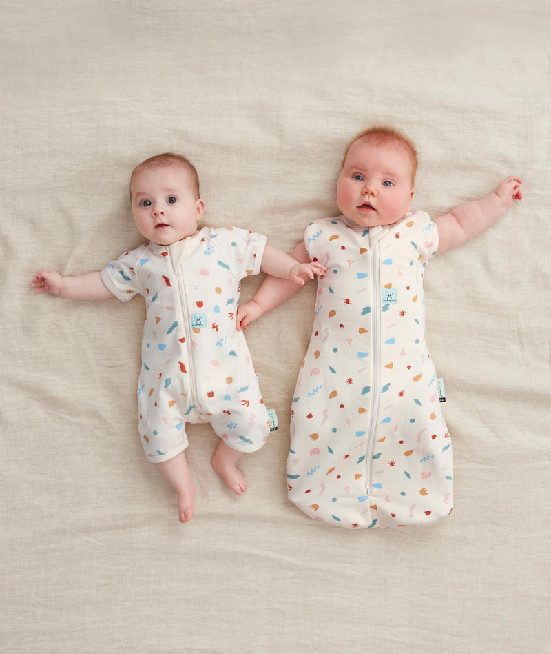 Two babies wearing ergoPouch sleepwear made from organic cotton