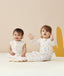 Two infants wearing ergoPouch sleepwear. One wearing a Sleeping Bag while the other wearing a Long Sleeve Layer.