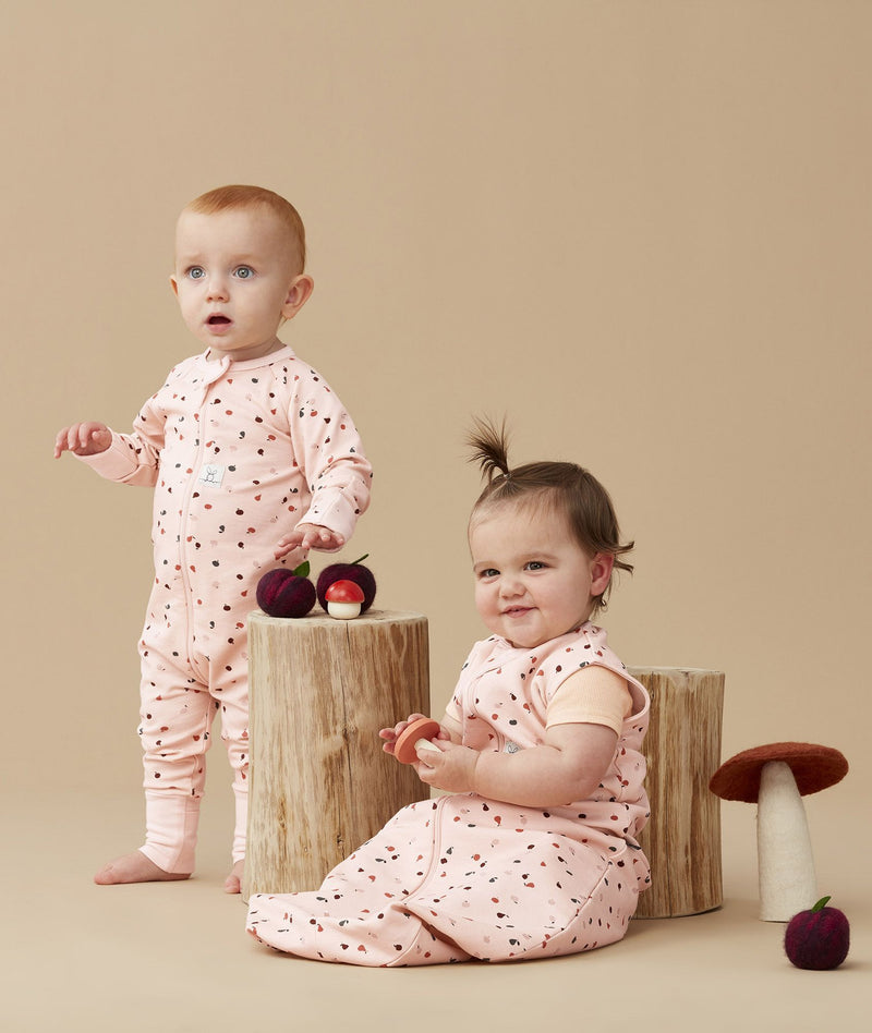 Two infants wearing ergoPouch sleepwear in Cute Fruit