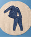 Blue Long Sleeve Pyjama set with a moon-and-star print, laid flat on a round quilted mat against a light blue background.