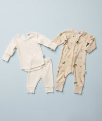 Two sets of ergoPouch baby sleepwear laid out on a light blue background. On the left is a long sleeve two-piece pyjamas in Oatmeal Marle. On the right is a long sleeve leyer, decorated with a colorful animal print.