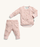 ergoPouch two-piece long sleeve baby pyjamas featuring a pink base color with an all-over daisy print and a press stud opening on shoulder.