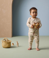 A toddler is wearing ergoPouch Long Sleeve Pyjamas made from soft, organic cotton for ultimate comfort.