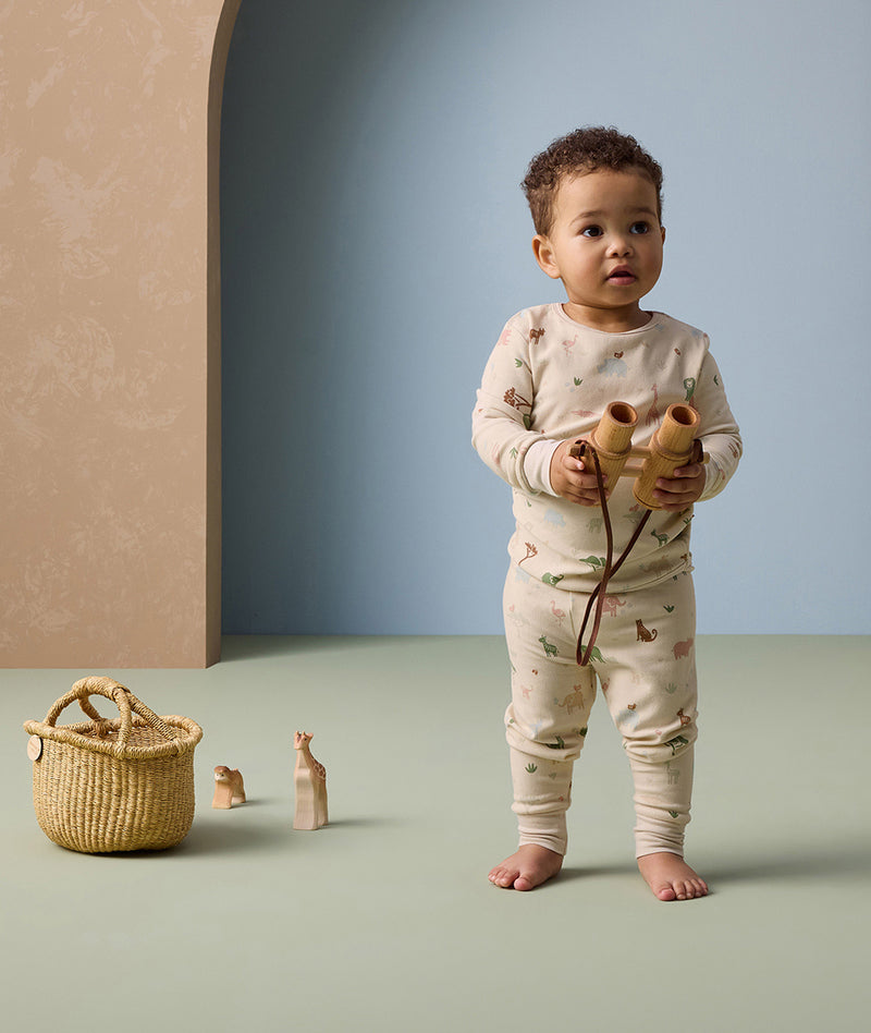 A toddler is wearing ergoPouch Long Sleeve Pyjamas made from soft, organic cotton for ultimate comfort.