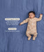 Sleeping baby in a tan patterned Long Sleeve Layer on a blue background, featuring text highlighting GOTS Organic Cotton and TOG-Rated features.