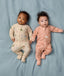 Two babies lying side by side wearing ergoPouch Long Sleeve Layer in Savannah and Elephant Parade.