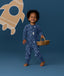 Toddler wearing a blue Long Sleeve Layer, standing against a blue background while holding a basket.