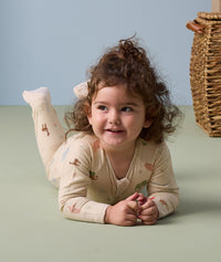 Toddler lying on its stomach wearing an ergoPouch Long Sleeve Layer in Savannah