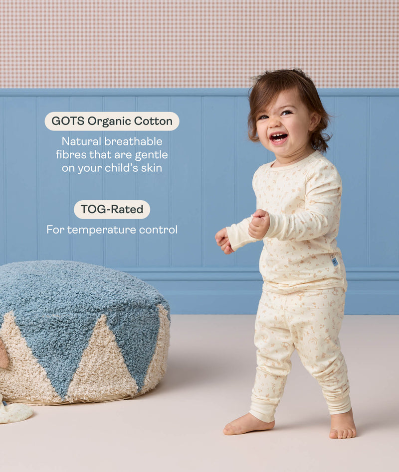 Happy toddler wearing ergoPouch Long Sleeve Pyjamas with text highlight on GOTS organic cotton and TOG rating