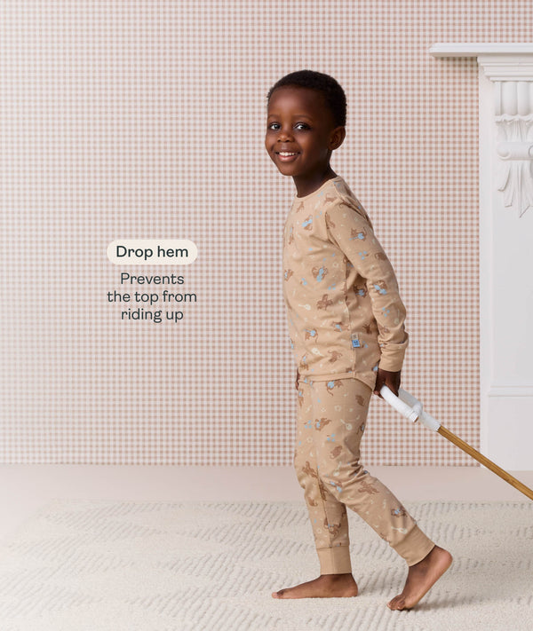 Preschooler in beige Long Sleeve Pyjamas, featuring a drop hem feature callout.