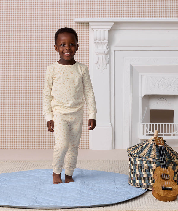 Preschooler wearing a cream patterned Long Sleeve Pyjama set, made from breathable, organic cotton for ultimate comfort.