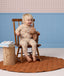 Toddler wearing a beige patterned Long Sleeve Pyjama Set sitting in a wooden chair holding a teddy bear.