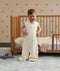 Toddler smiling with hands on hips, wearing a sleeveless convertible Sleep Suit Bag with separate legs.