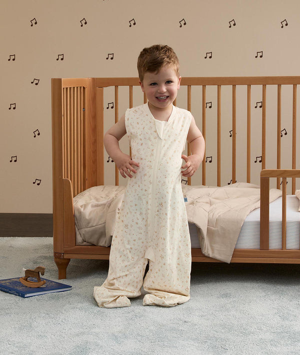 Toddler smiling with hands on hips, wearing a sleeveless convertible Sleep Suit Bag with separate legs.