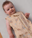 Close up of a baby wearing a Premium Sleeping Bag 1.0 TOG featuring a front zipper and animal print.