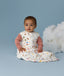 Infant sitting upright wearing a Premium Sleeping Bag 2.5 TOG with a long sleeve layer underneath.