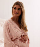 Pregnant mum wears a pink ergoPouch maternity robe, holding stomach