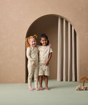 Two preschoolers are wearing ergoPouch two-piece pyjamas Savannah. The child on the left is in long sleeve pyjamas, while the child on the right is in short sleeve ones.